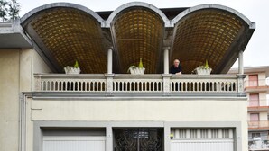 A building with a balcony, two garage doors, and a decorative metal gate. - Il Terrazzo B&B (Romagnano Sesia)