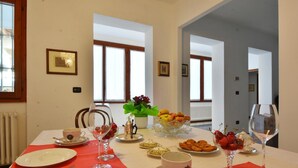 A dining table set with plates, cutlery, glasses, and a variety of food items. - Il Terrazzo B&B (Romagnano Sesia)