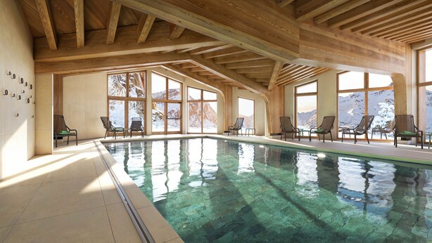 An indoor swimming pool with wooden beams, large windows, and lounge chairs. - Résidence Pierre & Vacances Capella (Morzine)