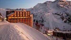 A modern hotel with a ski slope in the background. - Résidence Pierre & Vacances Capella (Morzine)