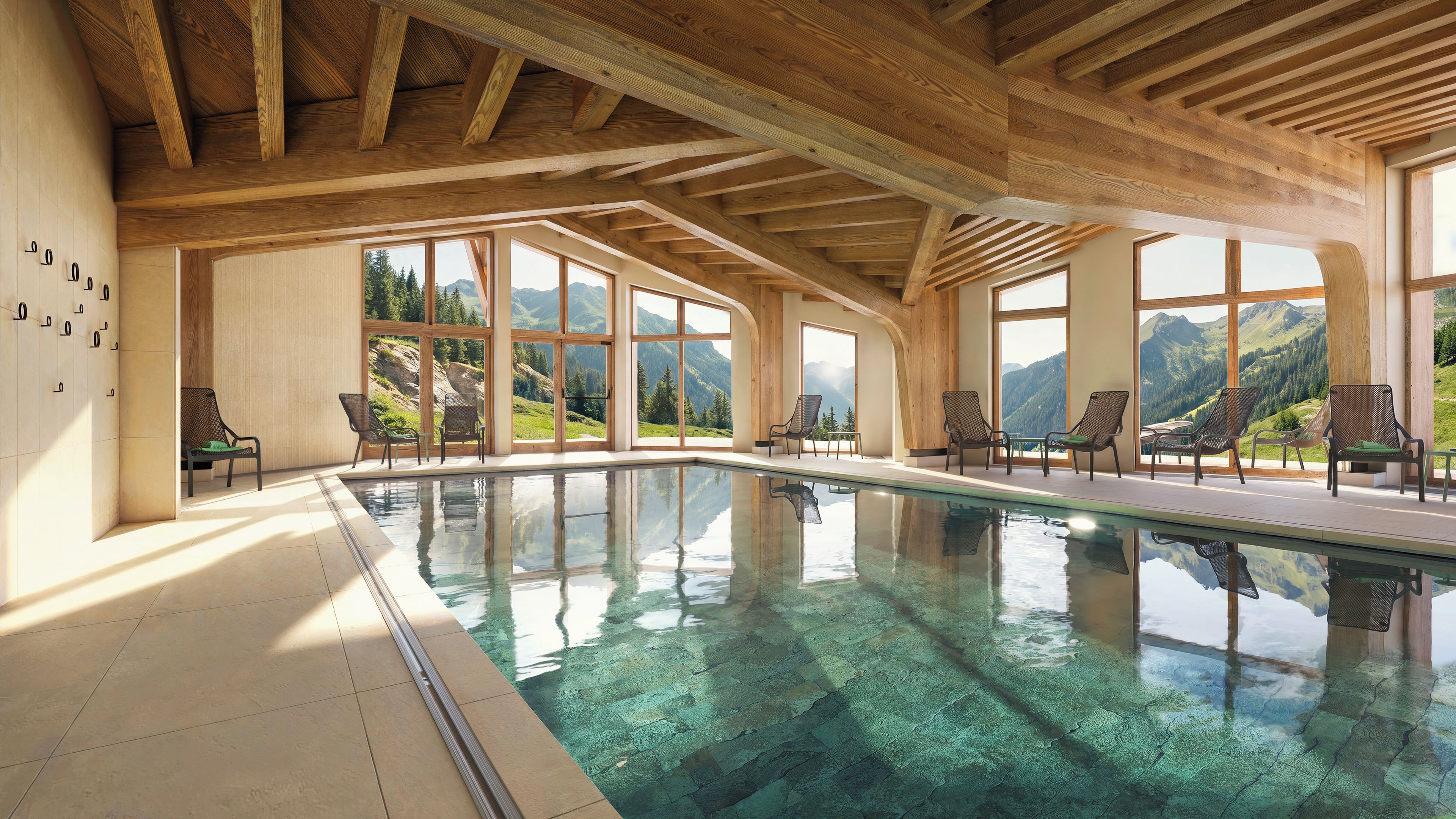 Piscina con agua cristalina, vigas de techo de madera y vistas a la montaña a través de amplios ventanales.