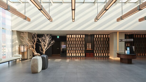 A spacious lobby with a modern design, featuring a check-in counter, seating area, and decorative vases. - NINE TREE BY PARNAS SEOUL INSADONG (Seoul)