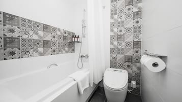 A modern bathroom with a bathtub, toilet, and shower.