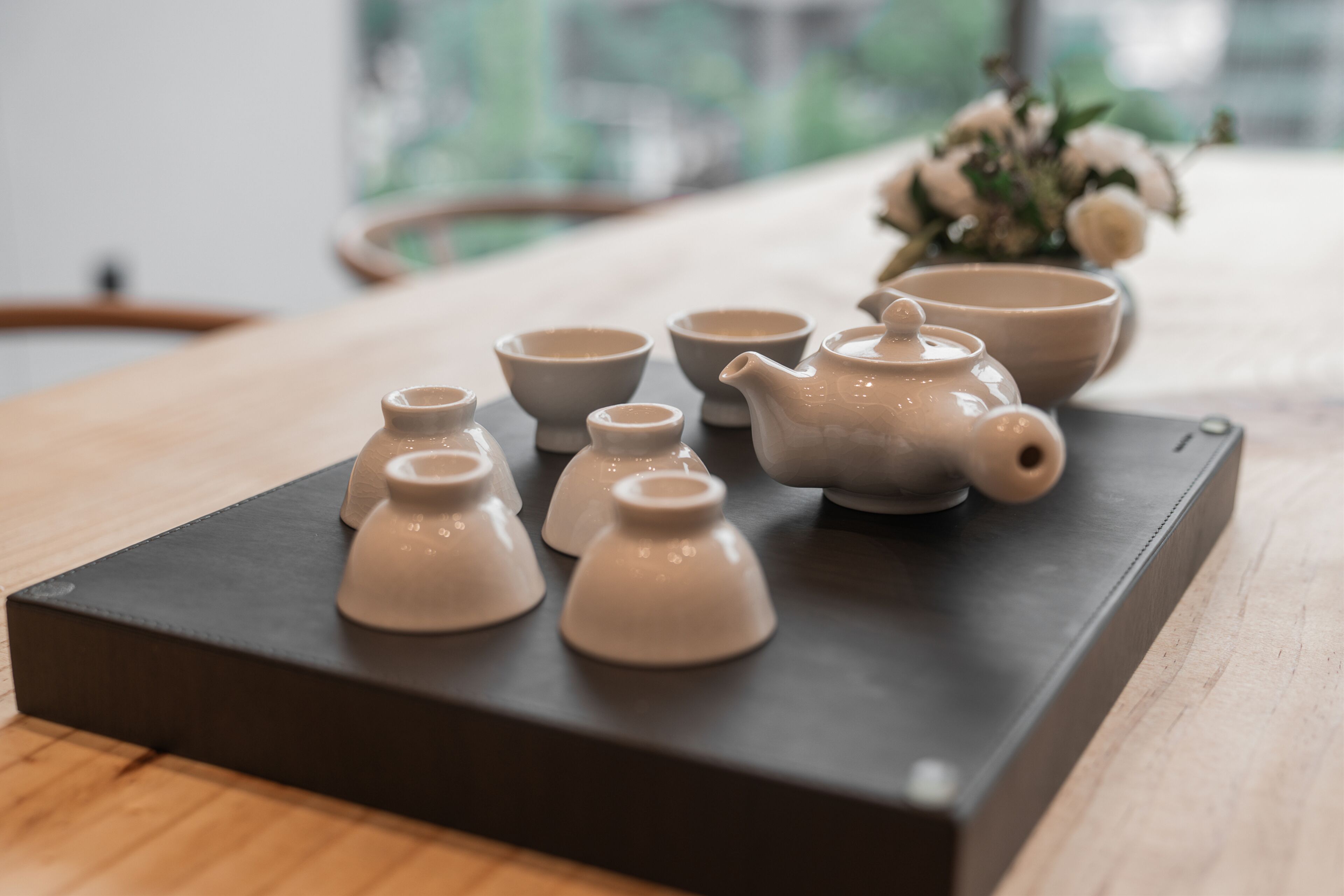 A set of ceramic tea ware on a black tray.