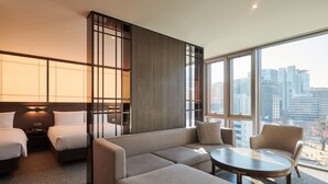A modern hotel room with a large bed, a sofa, a small table, and a view of the city skyline. - NINE TREE BY PARNAS SEOUL INSADONG (Seoul)