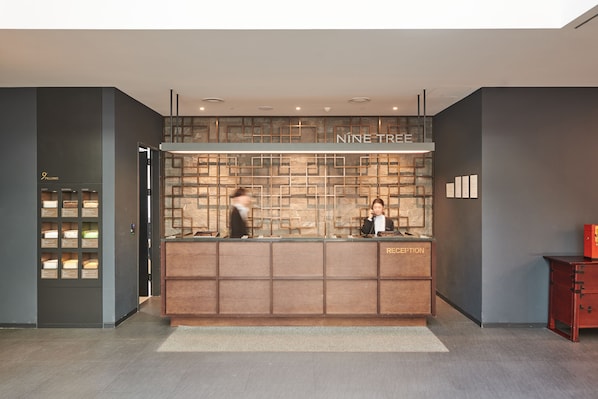 A reception desk with a wooden panel design, a nameplate reading "NINE TREE," and a reception area labeled "RECEPTION." - NINE TREE BY PARNAS SEOUL INSADONG (Seoul)