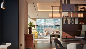 A modern interior with a dining area, a wooden cabinet, and a view of a cityscape through large windows. - NINE TREE BY PARNAS SEOUL INSADONG (Seoul)