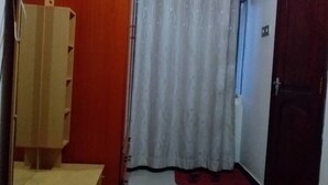 A room with a red wall, a white curtain, and a wooden door. - Vegas Hotel (Kampala)