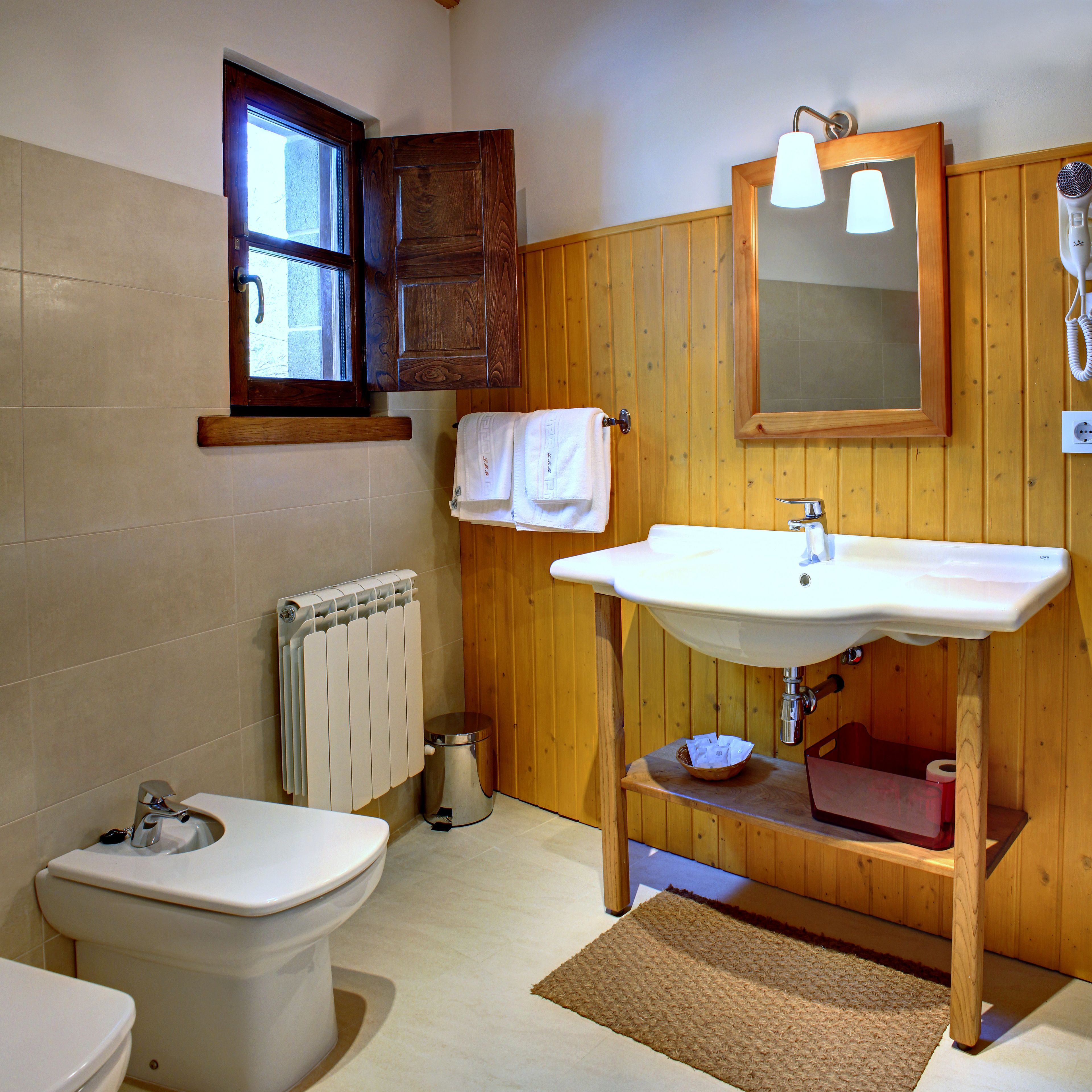 Un baño con inodoro, lavamanos y ventana.