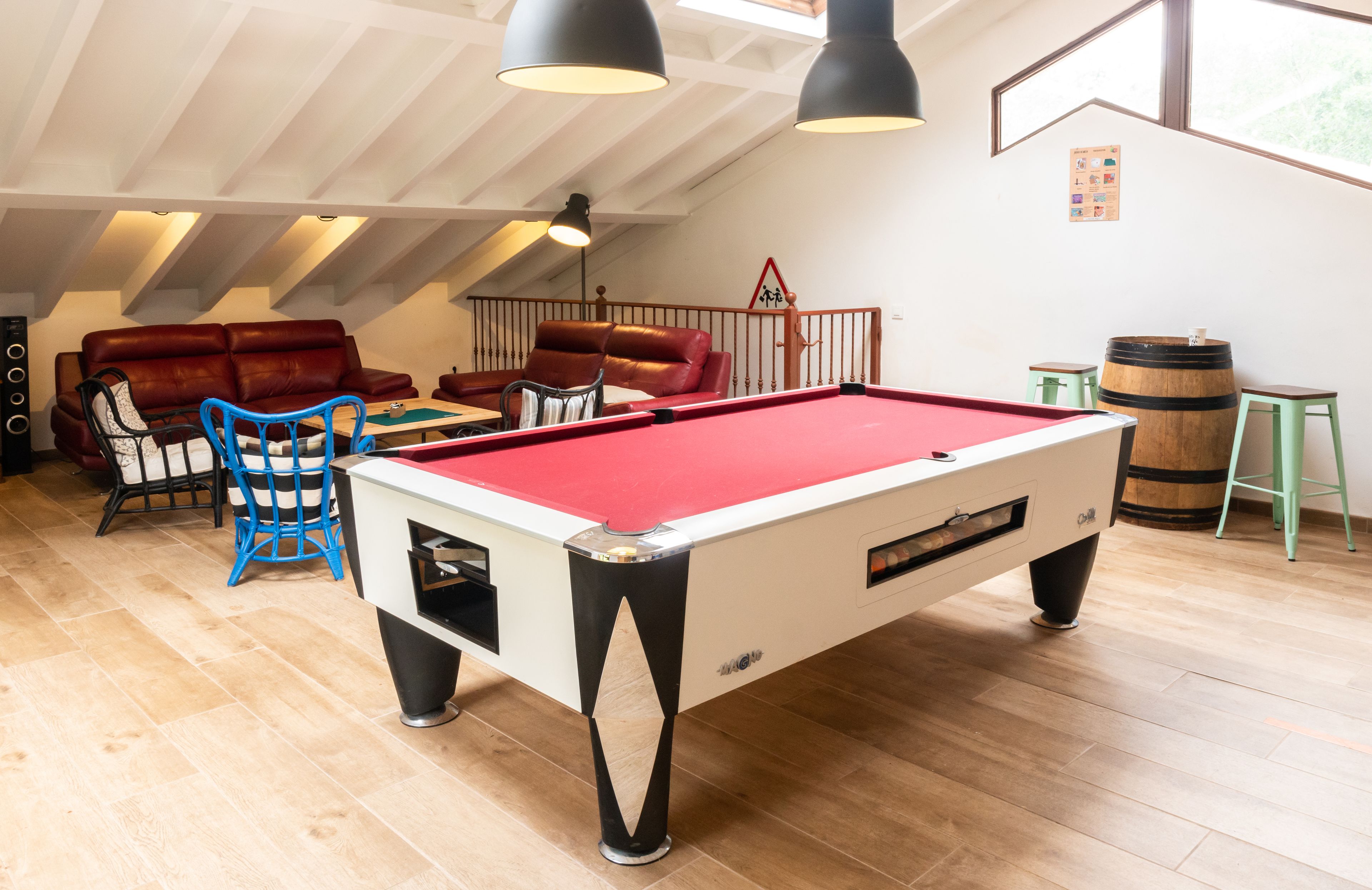 A cozy room with a pool table, leather sofas, and a billiards rack.