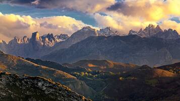 Un paisaje montañoso con terreno accidentado y una cordillera de picos.