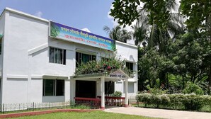 A building with a signboard, a covered entrance, and a well-maintained lawn. - Kuakata Guest House (Kalapara)