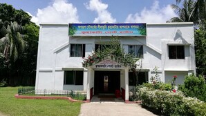 A building with a sign in a non-English script, a gated entrance, and a well-maintained lawn. - Kuakata Guest House (Kalapara)