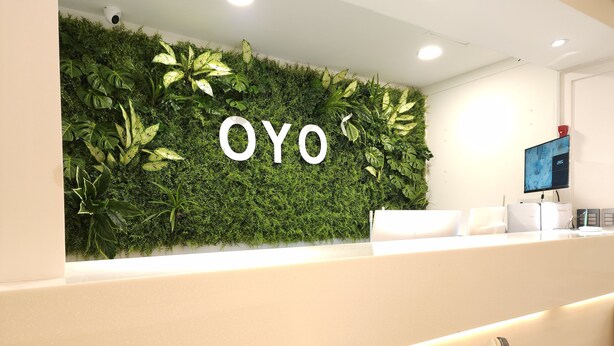 A reception area with a green wall and the word "OYO" prominently displayed. - OYO Hostel Myeongdong 5 (Seoul)