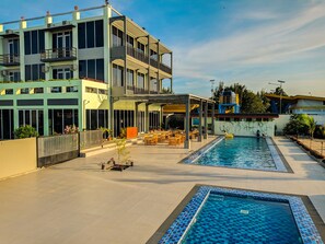A modern hotel with a rooftop pool area, outdoor seating, and a covered patio. - Hotel Moloka’I Morotai (Morotai Island)