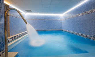 Una piscina techada, sillones reclinables de piscina