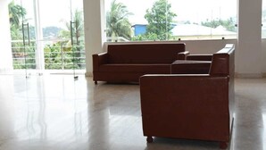 A spacious room with a large window offering a view of greenery and buildings outside. - Hotel Waanderers Howff (Port Blair)