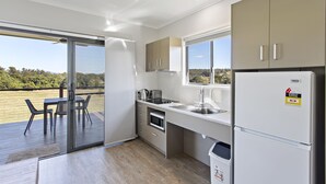 A modern kitchen with a view of the outdoors, a dining area with a table and chairs, and a built-in oven.