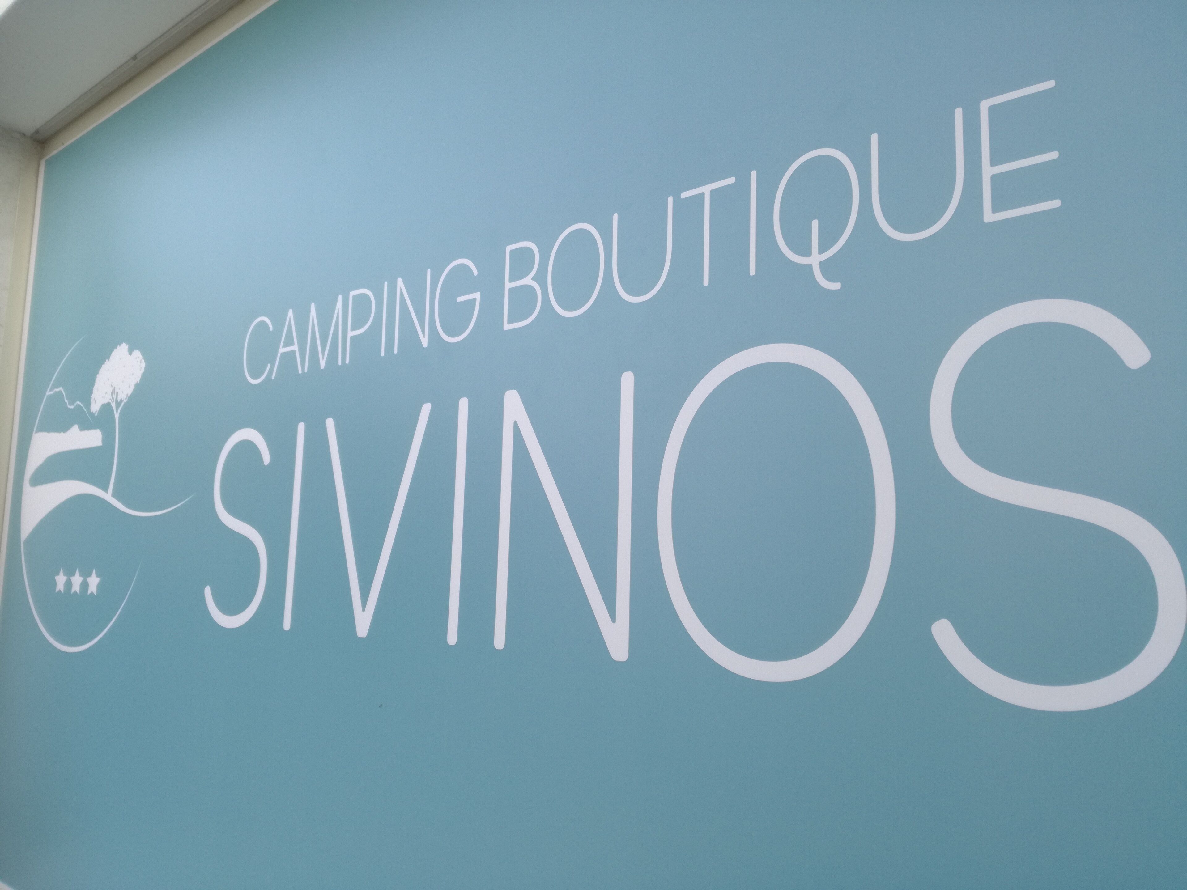 A wall with the text "CAMPING BOUTIQUE SIVINOS".