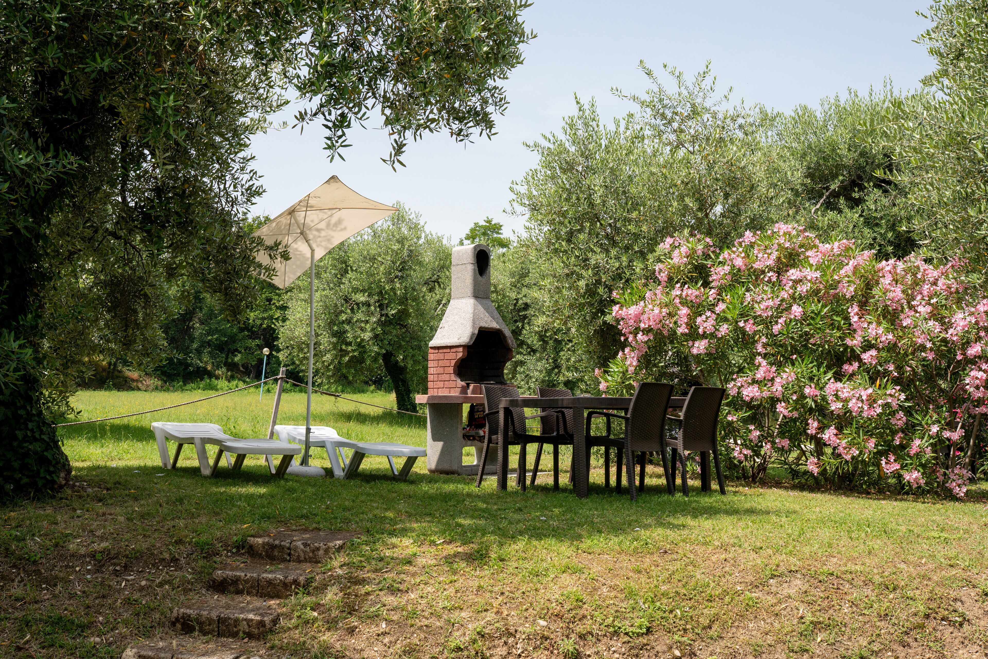 Une terrasse extérieure équipée d’un barbecue, de sièges et d’une pergola.