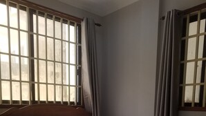A neatly made bed with white bedding and a red accent, a wooden headboard, and a window with curtains. - Wei Si Deng Hotel and Restaurant (Phnom Penh)
