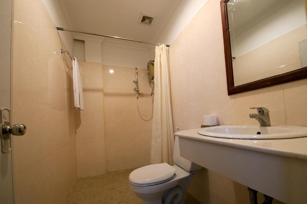 Een compacte badkamer met toilet, wastafel en douche.