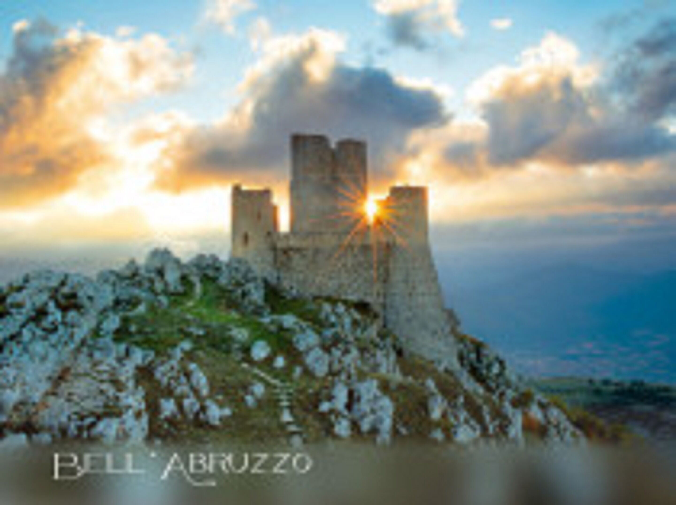 A castle on a hill with a sunset in the background.