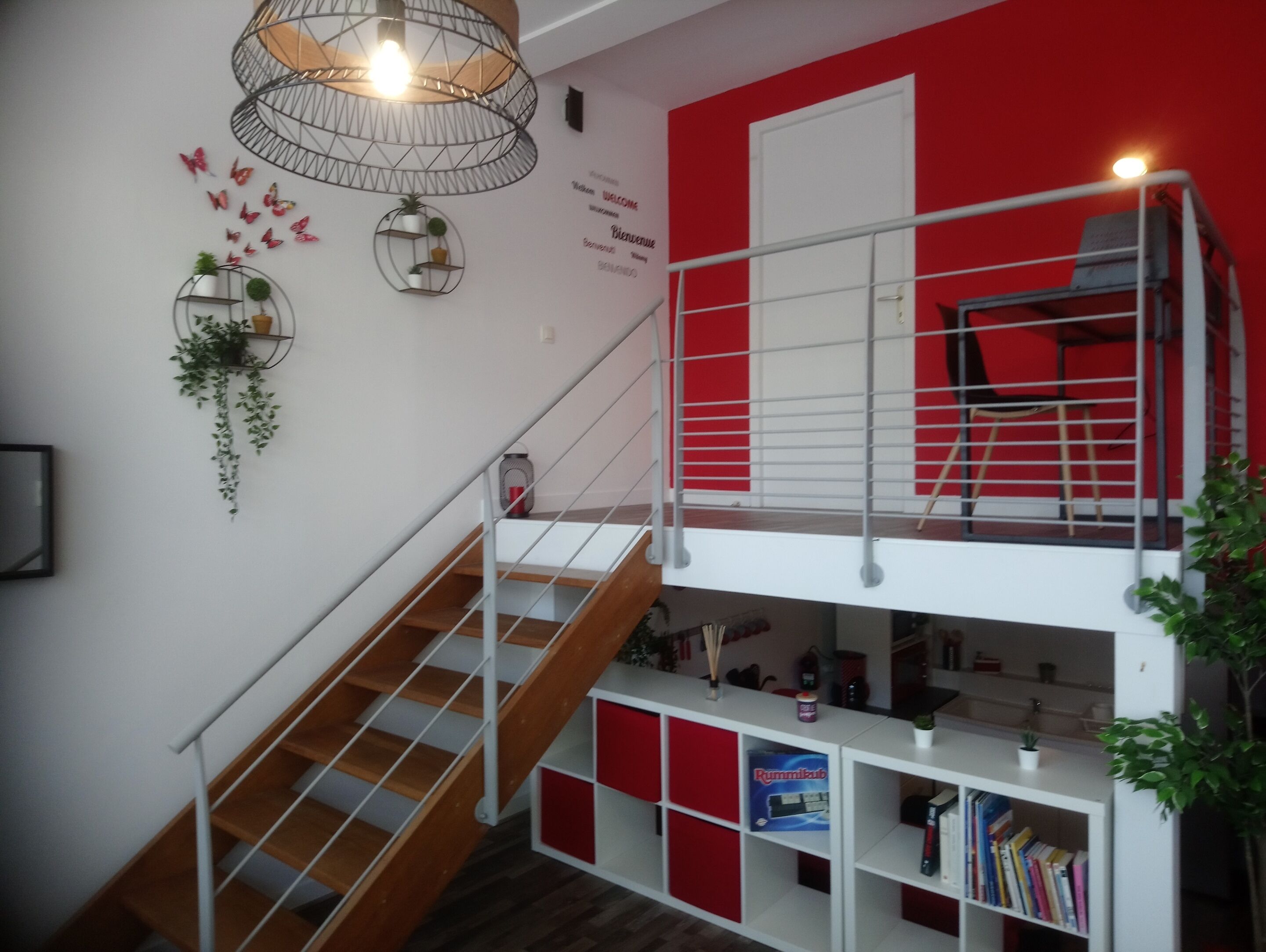 A multi-level interior with a staircase, red and white color scheme, and various decorative elements.