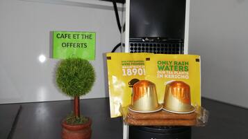 A small potted plant, a Krups water dispenser, and promotional materials on a table.