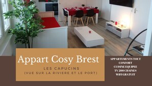 A modern apartment with a dining area, kitchenette, and a TV. It includes amenities like a TV with 200 channels and free WiFi. - Appart Cosy Brest Les Capucins (Brest)