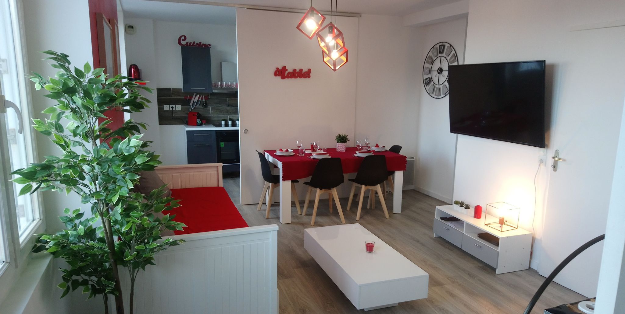A modern apartment with a dining area, kitchenette, and a TV. It includes amenities like a TV with 200 channels and free WiFi.
