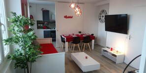 A modern apartment with a dining area, kitchenette, and a TV. It includes amenities like a TV with 200 channels and free WiFi. - Appart Cosy Brest Les Capucins (Brest)