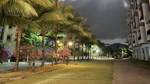 A street lined with palm trees and a building with balconies. - Thuy Nga Hotel Phu Quoc (Phu Quoc)