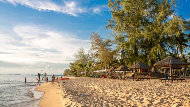 A beach with thatched umbrellas, sun loungers, and palm trees. - Thuy Nga Hotel Phu Quoc (Phu Quoc)
