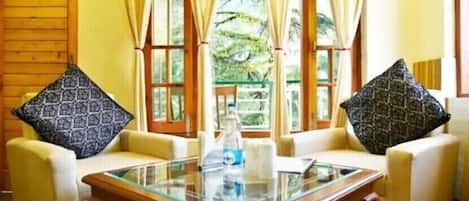 Habitación Deluxe | Área de sala de estar | Televisión de pantalla plana