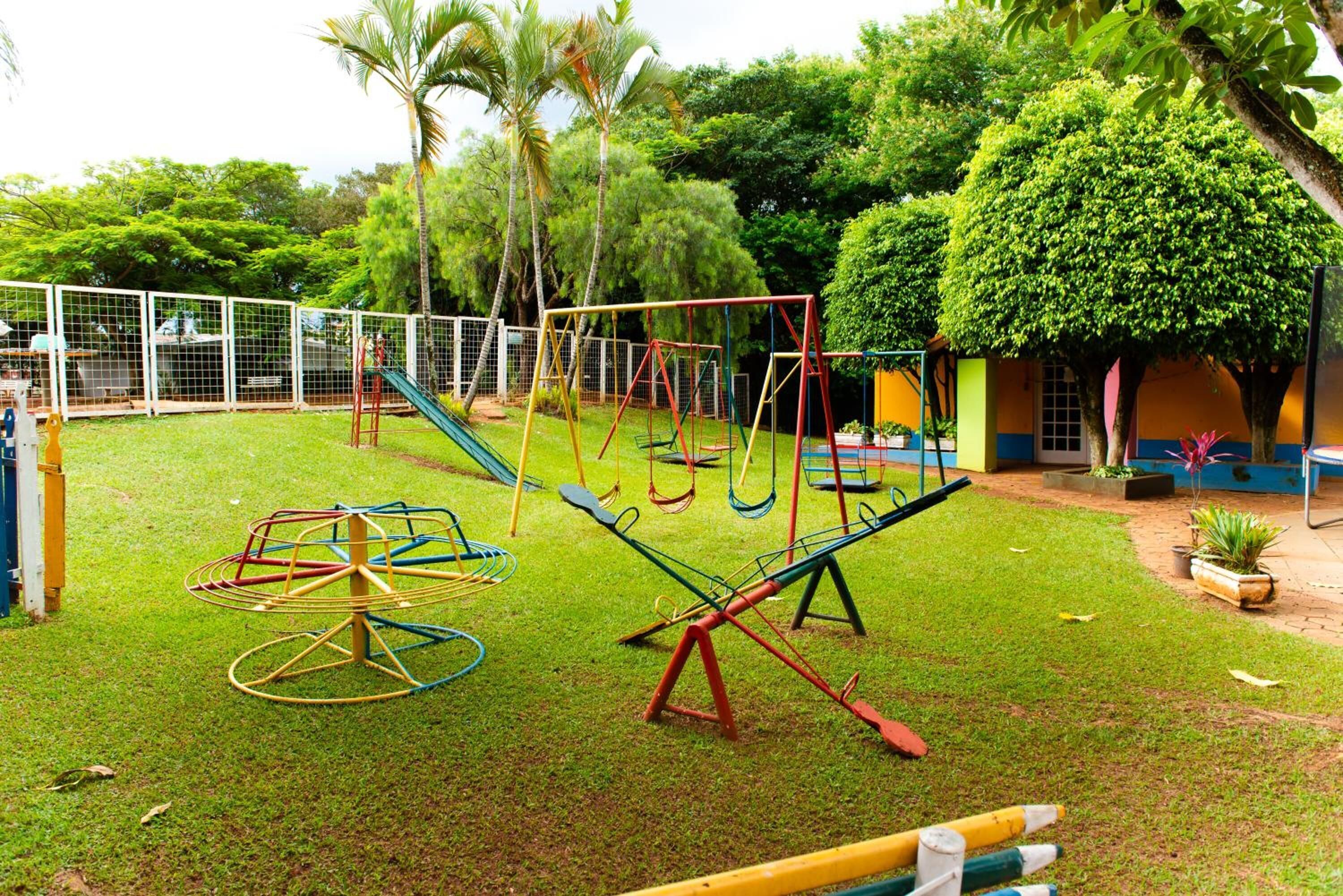 A playground with swings, a seesaw, and a merry-go-round.