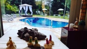 Un cuarto de spa con vista a la piscina, toallas y una estatua.