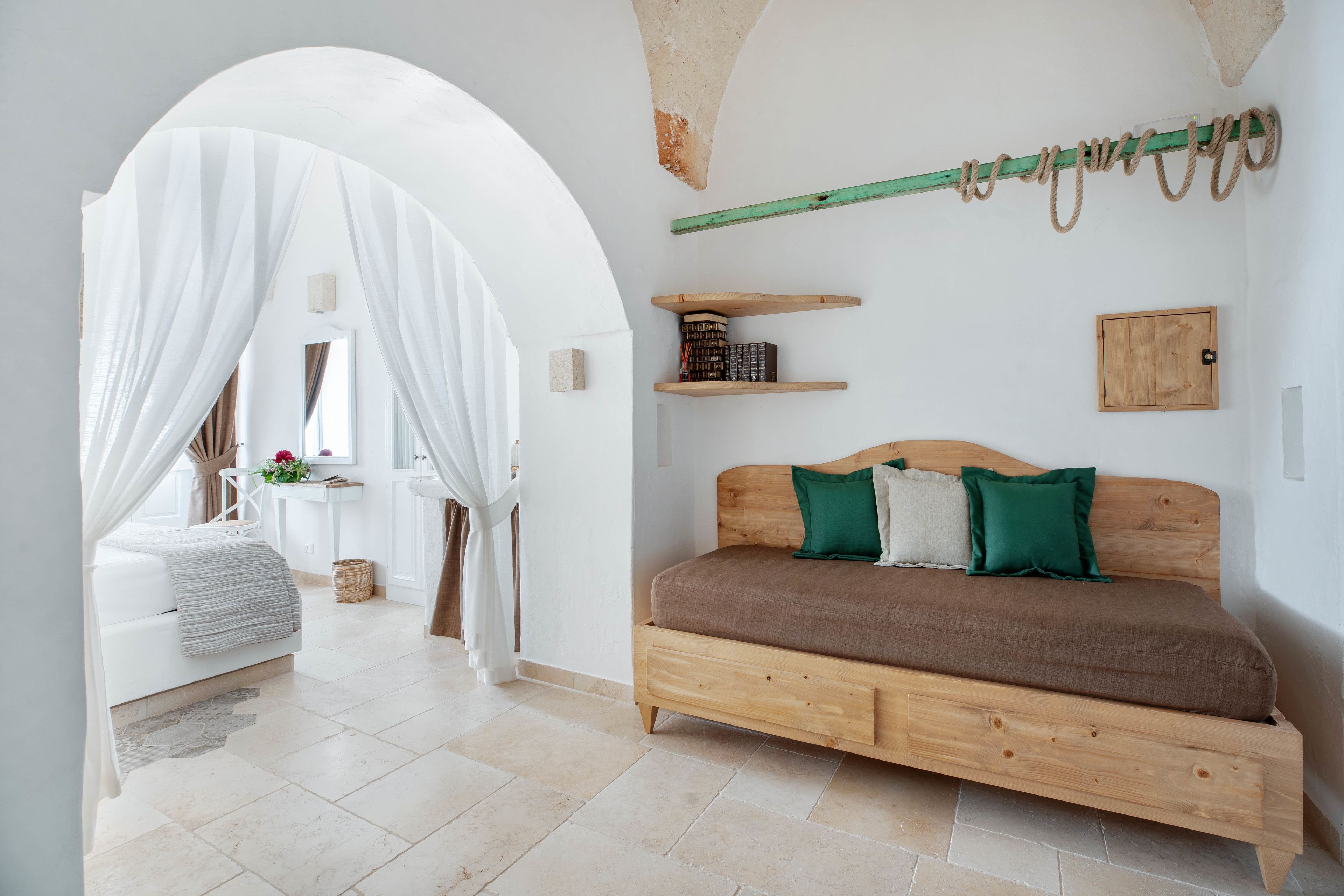 A bedroom with a wooden bed, a canopy bed, and a small shelf with books.