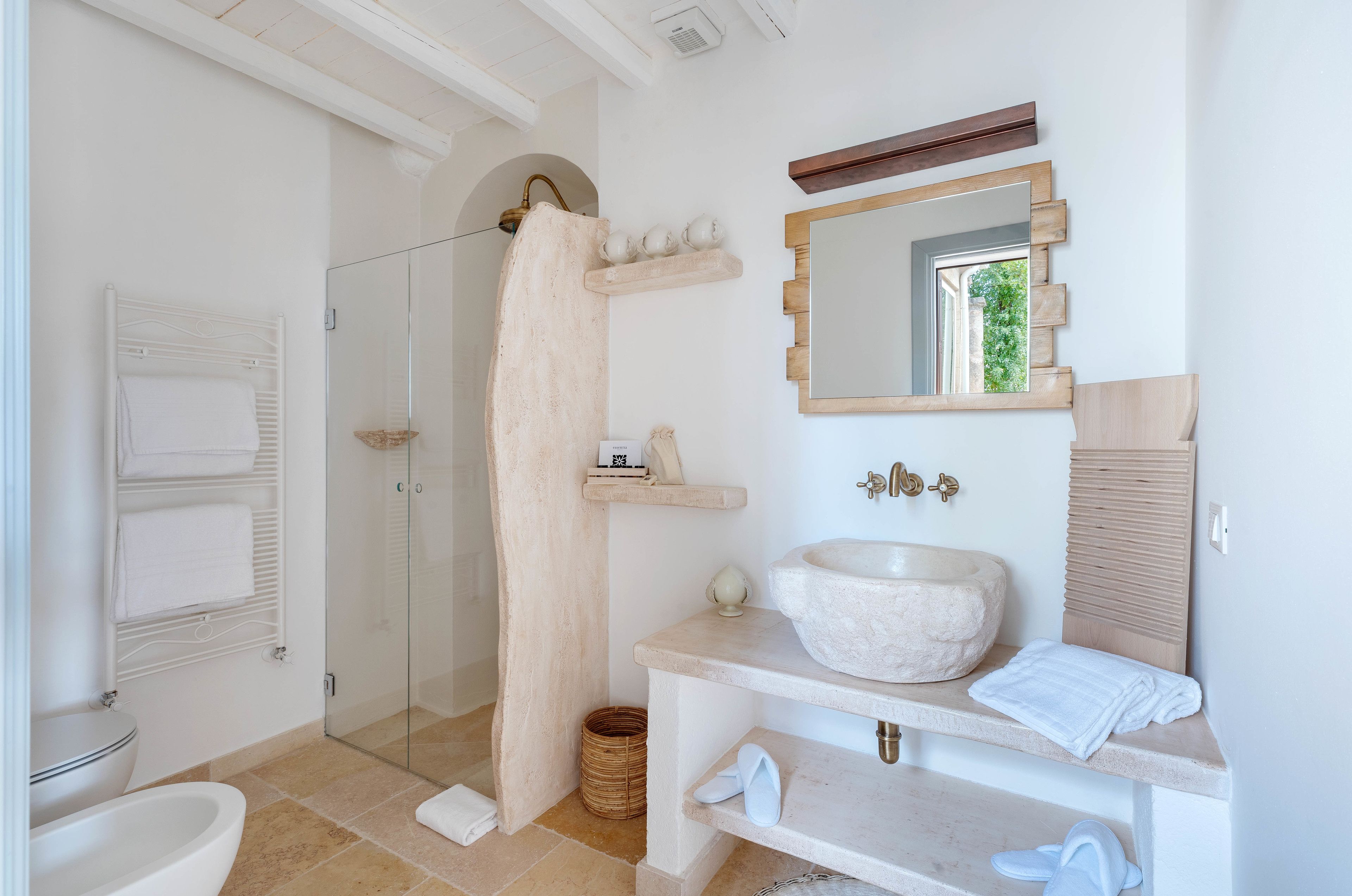 A modern bathroom with a glass shower, a white sink, and a large mirror.