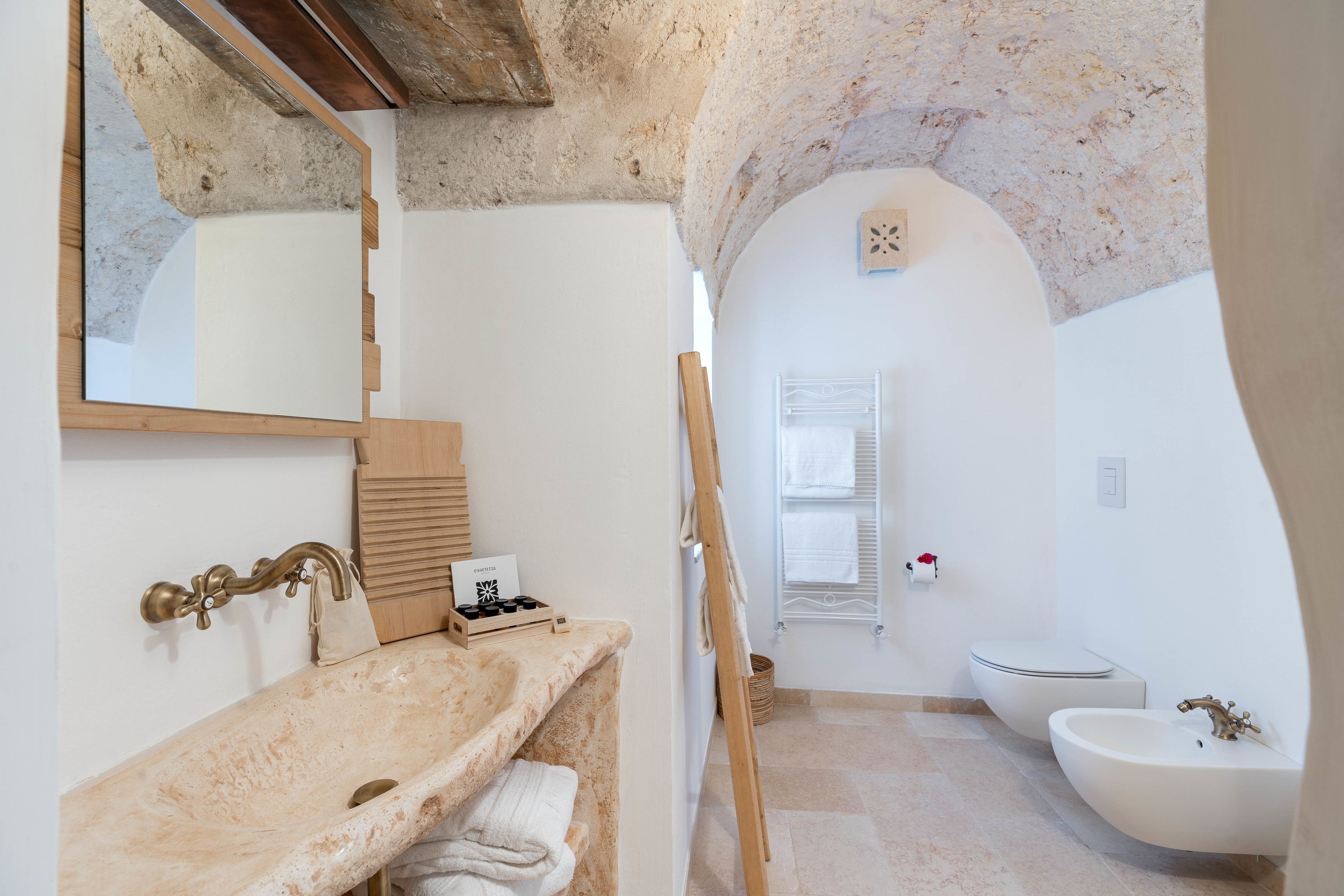 A bathroom with a freestanding bathtub, a sink, and a mirror.
