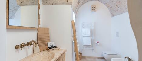 A bathroom with a freestanding bathtub, a sink, and a mirror.
