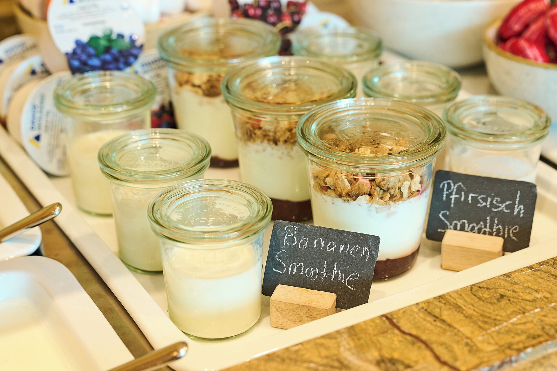 Un plat amb pots d'alimentació, incloent un cartell amb la inscripció 'Banana Smoothie' i 'Pfrißich Smoothie'.