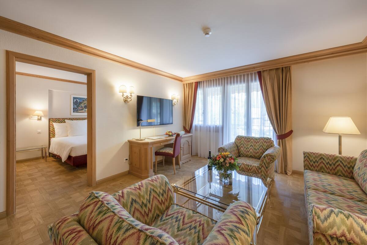 Une chambre d’hôtel comprenant un lit, un bureau avec une chaise, une télévision et un canapé.