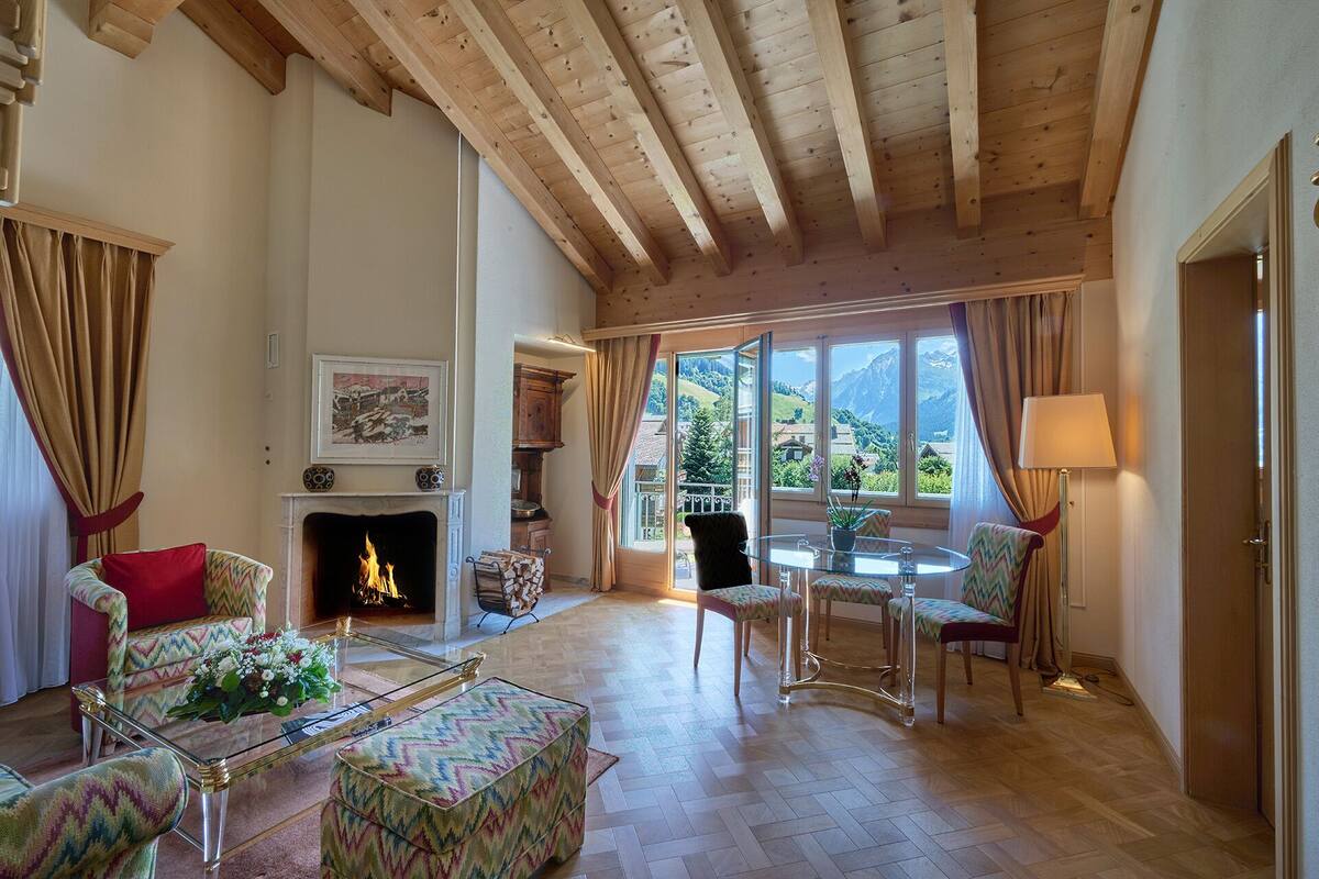 Un salon chaleureux avec une cheminée, un coin repas et une vue sur les montagnes.