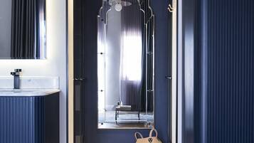 Un baño moderno con tocador, un espejo grande y un perchero para toallas.