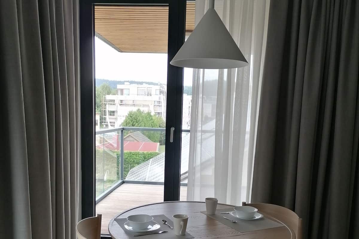 Un comedor con una mesa redonda, cuatro sillas y una lámpara colgante.