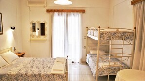 Una habitación con literas, una mesita de noche, un espejo y una ventana con cortinas.