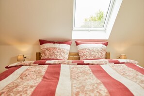 A bedroom with a large bed, floral-patterned bedding, and a skylight. - Susannes Burgblick (Bernkastel-Kues)