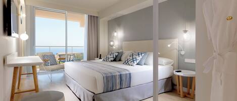 Una camera d'albergo moderna con un letto grande, comodini, una scrivania e vista sull'esterno.
