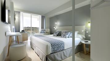 A modern hotel room with a large bed, bedside tables, a round ottoman, and a view of the outdoors.